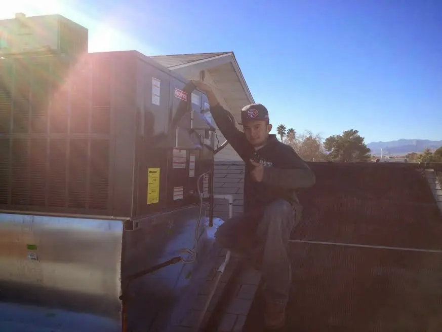 HVAC technician performing Heat Pump Repair on a rooftop unit in Lake Norman of Catawba